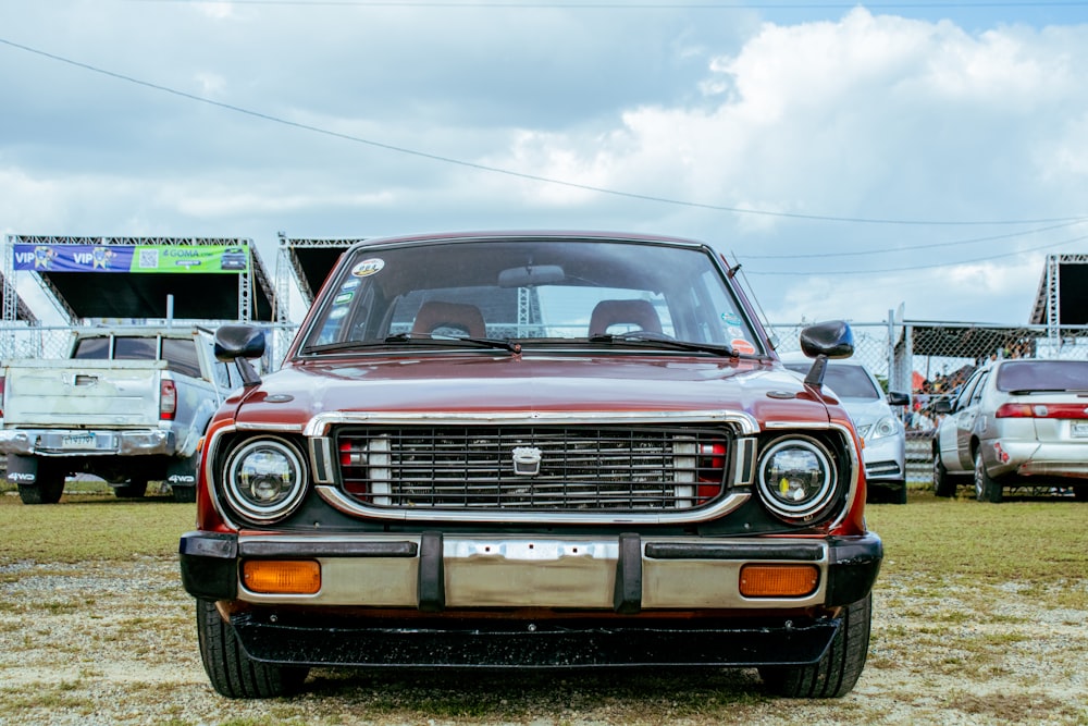 a red truck parked on top of a grass covered field