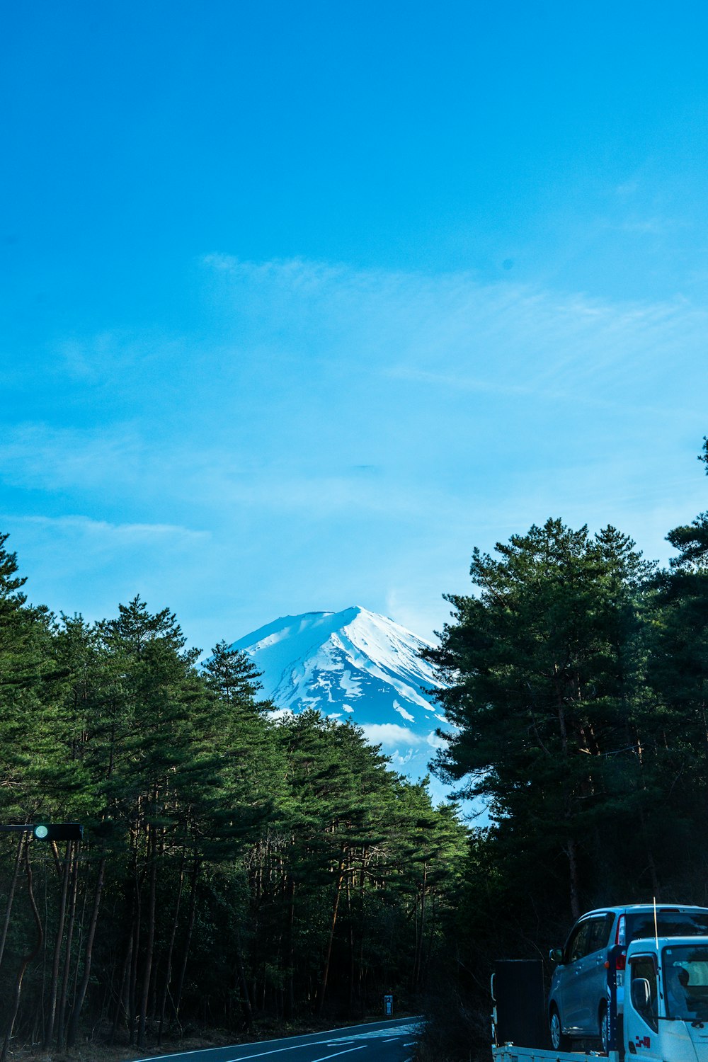 a van driving down a road with a mountain in the background