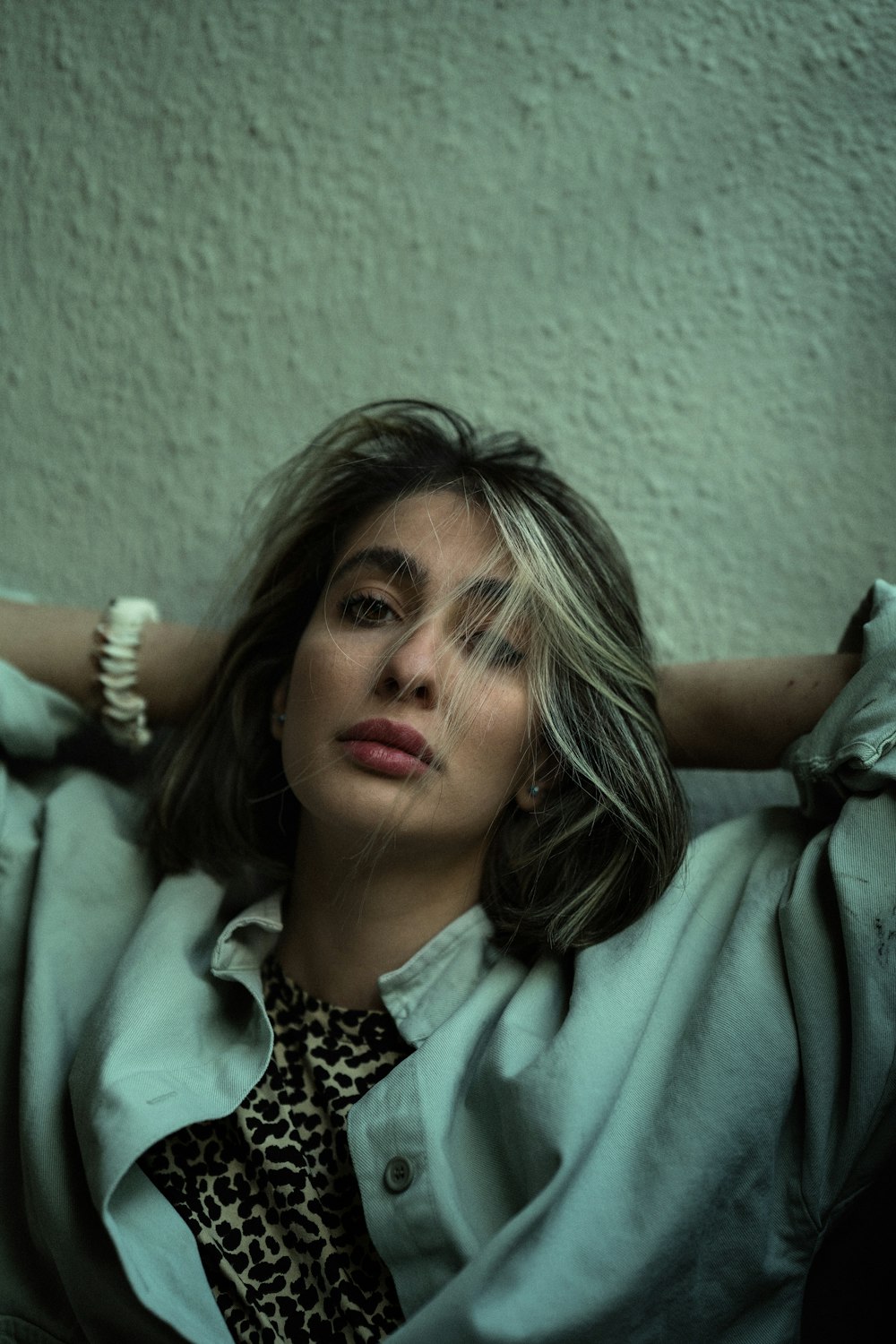 a woman in a blue coat and leopard print shirt