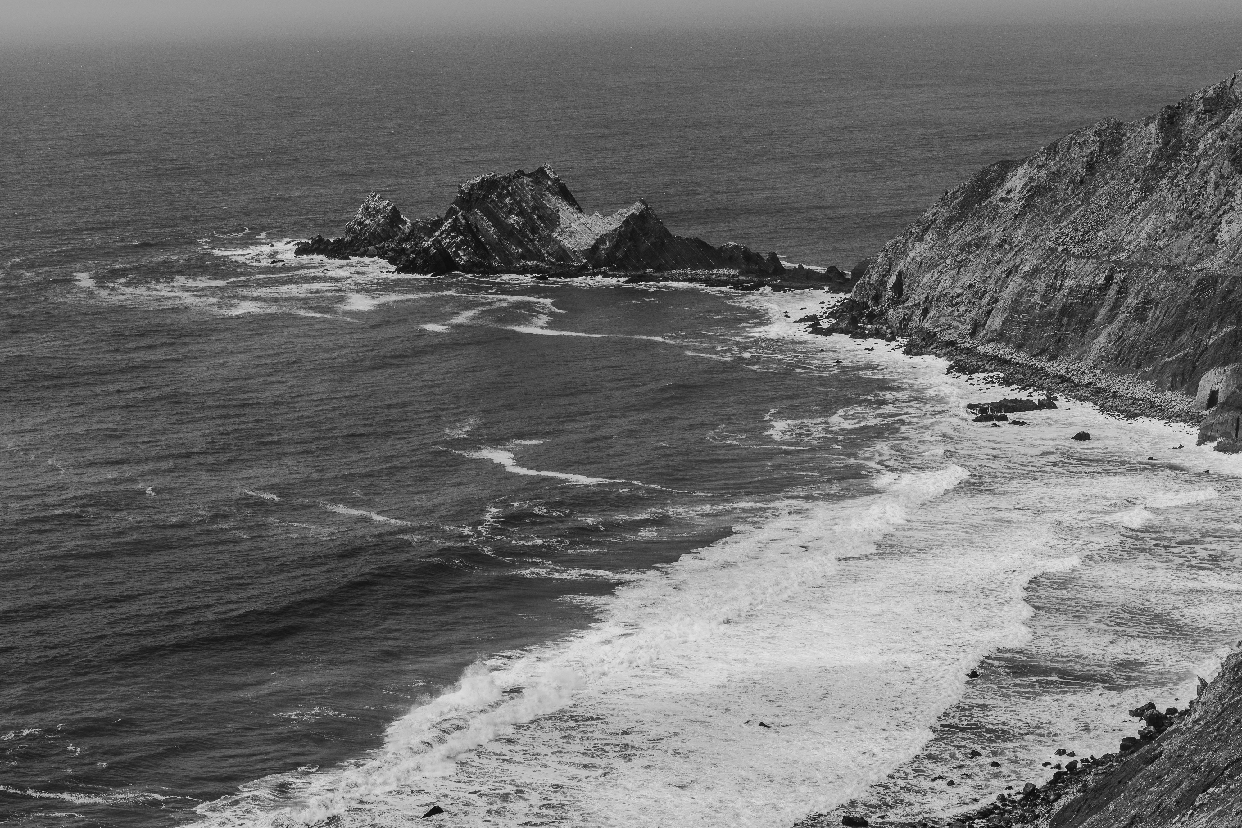 a black and white photo of a rocky coastline