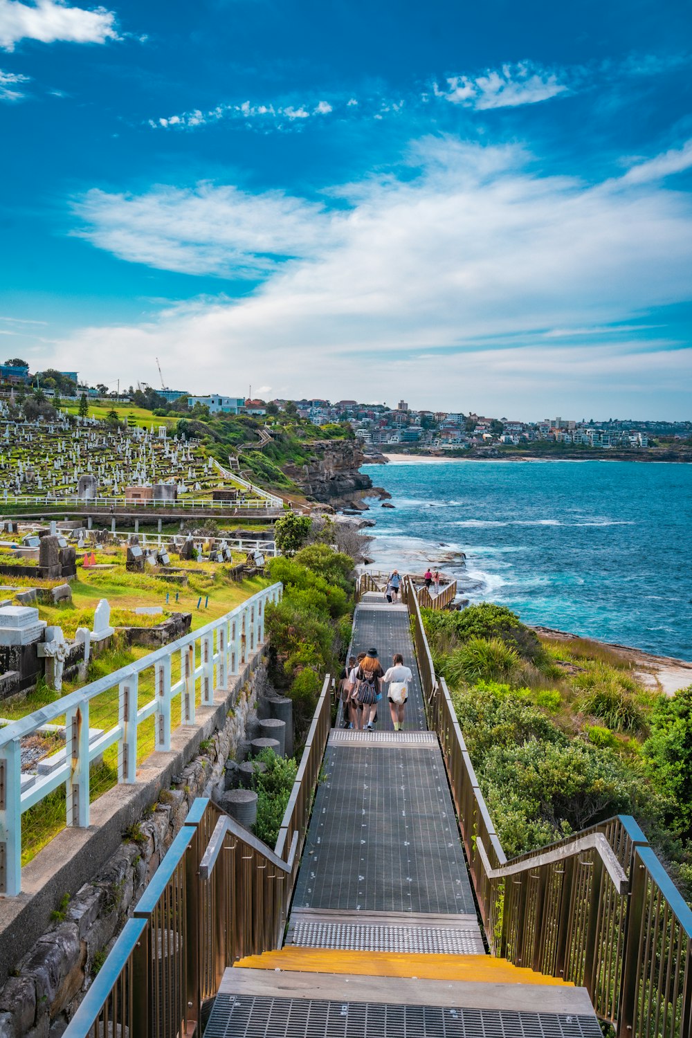 a group of people walking up a set of stairs next to the ocean