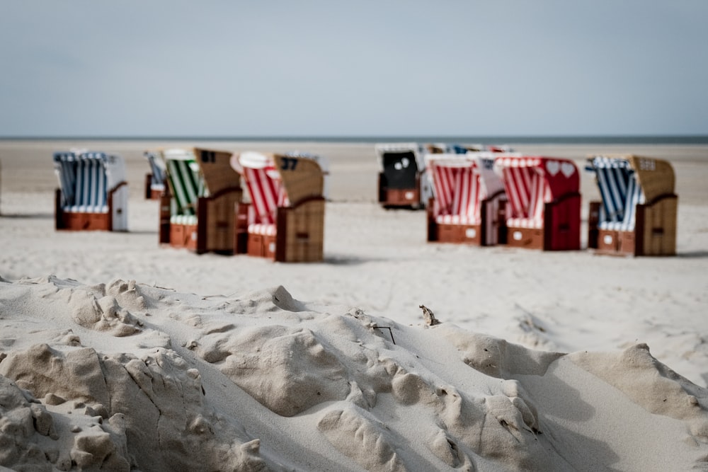 a row of beach chairs sitting on top of a sandy beach