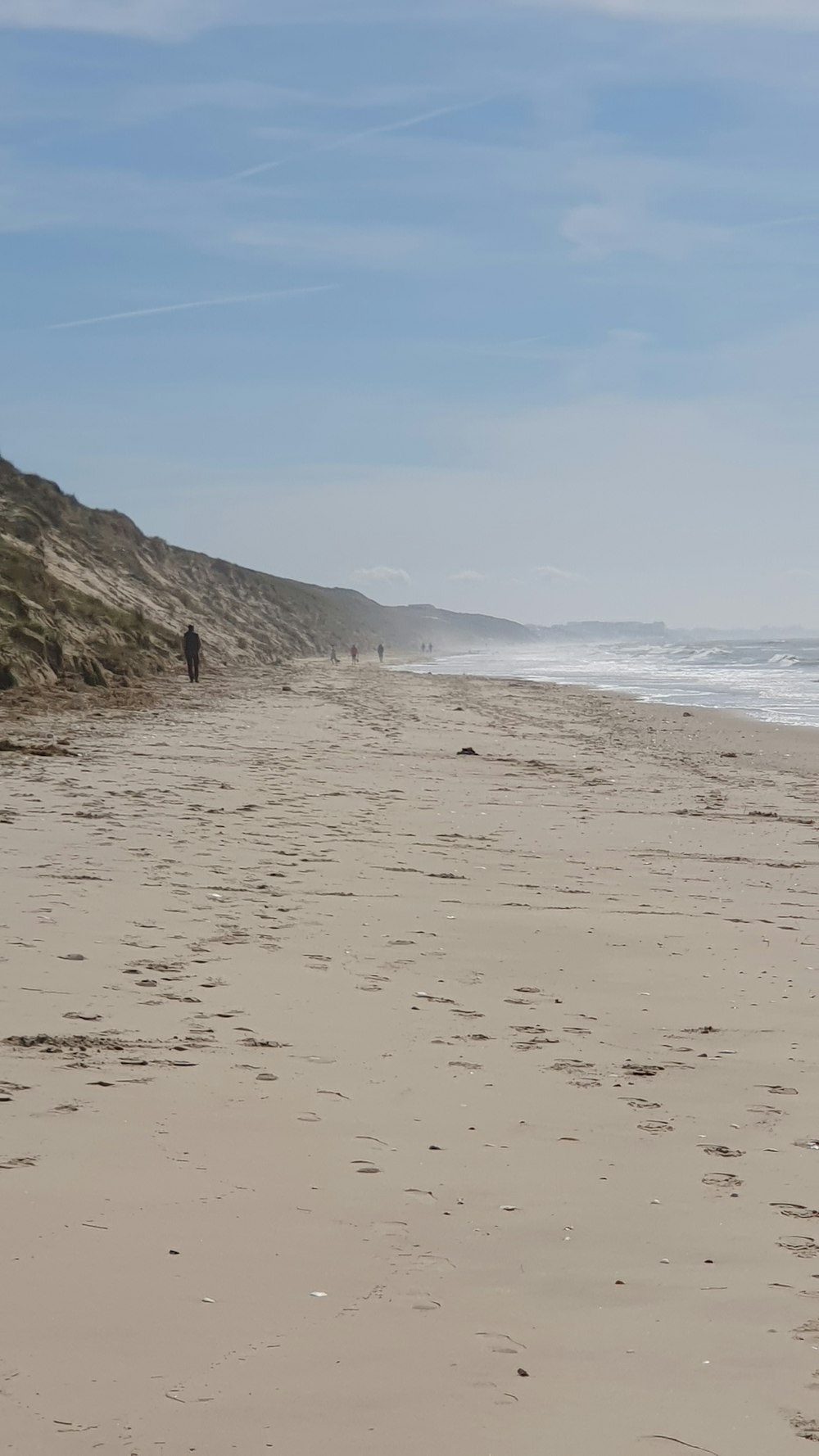 a person walking on a beach with a surfboard