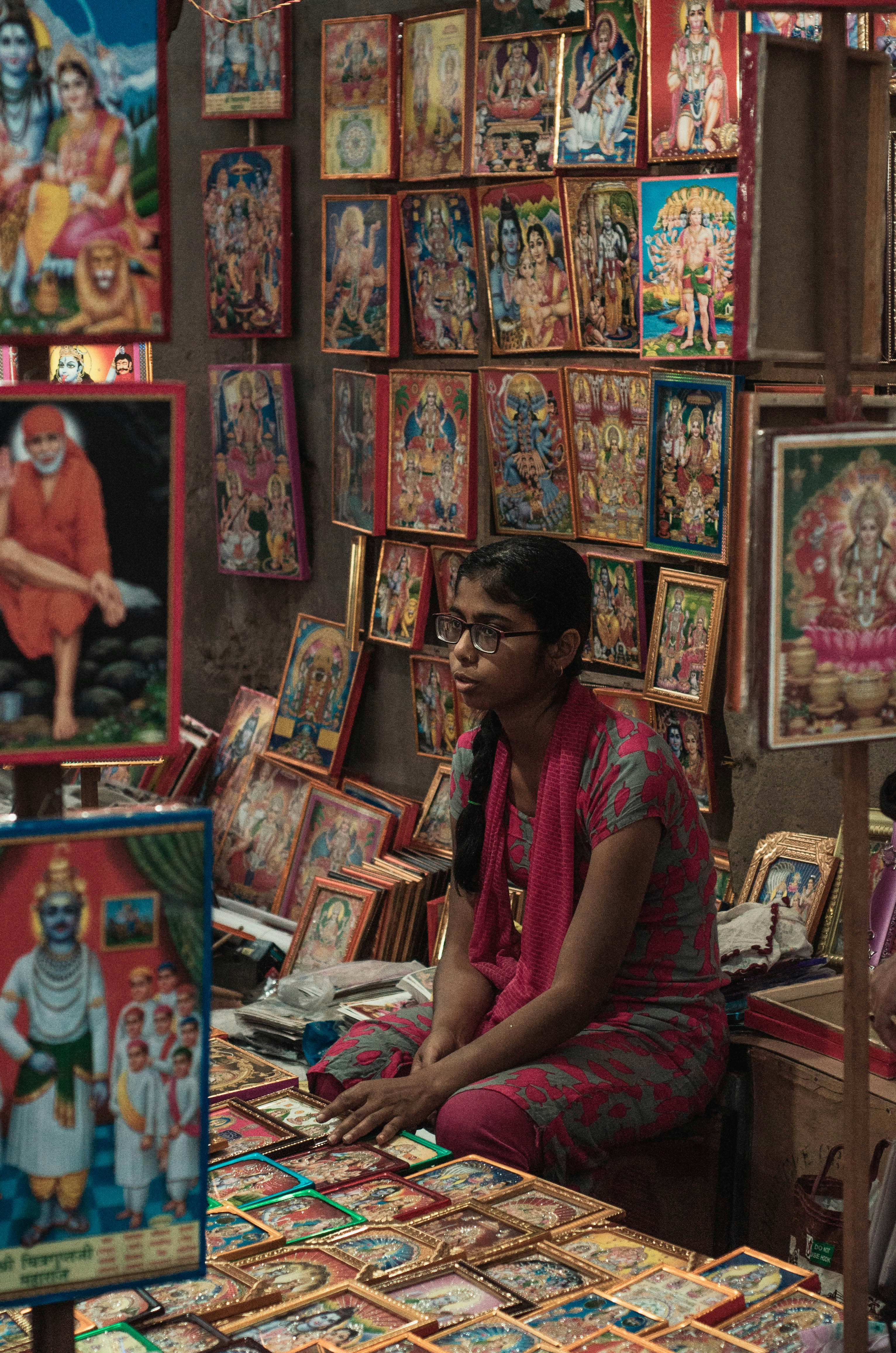 a man sitting in front of a table covered in paintings