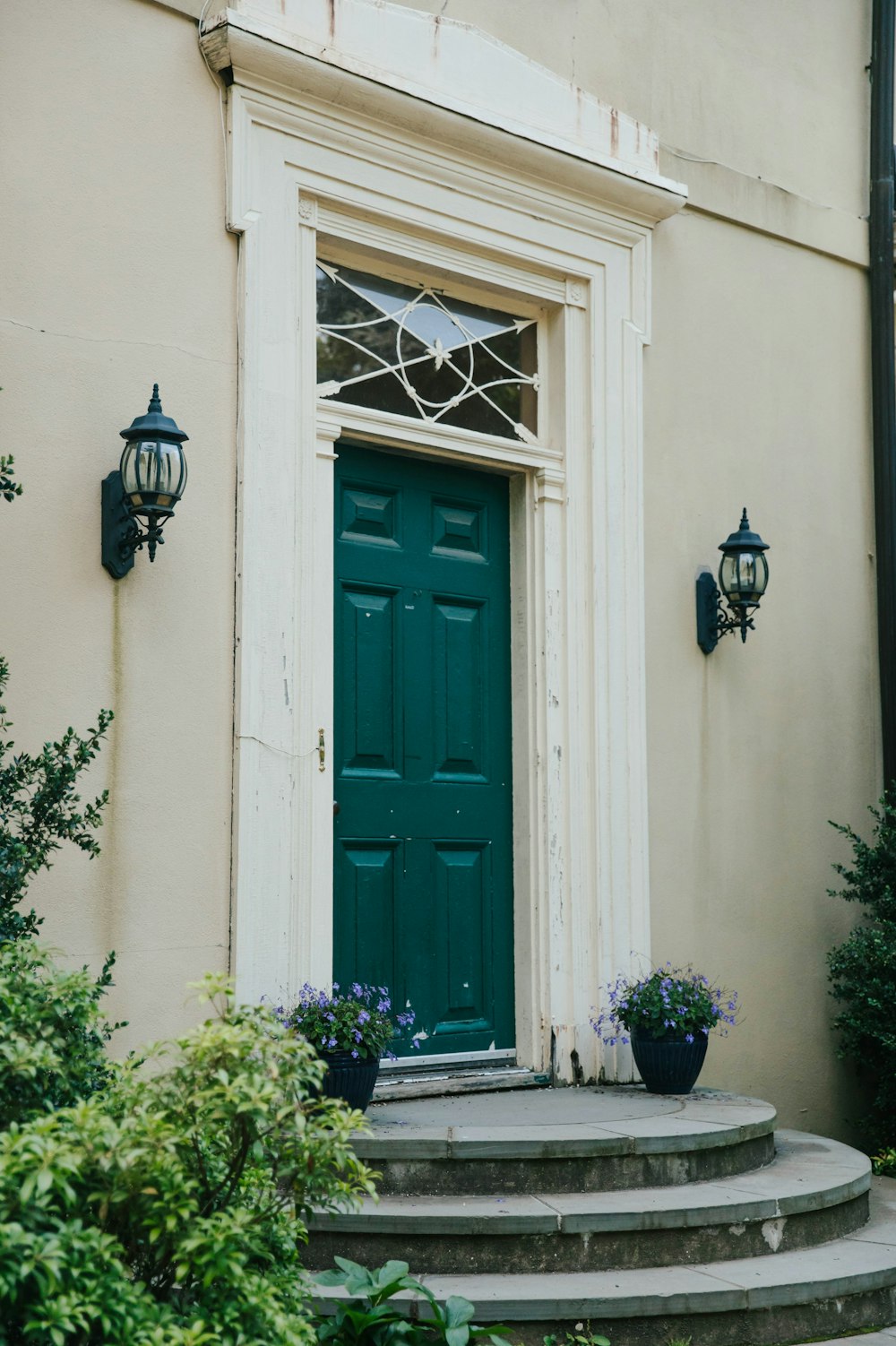 a green door and steps in front of a house