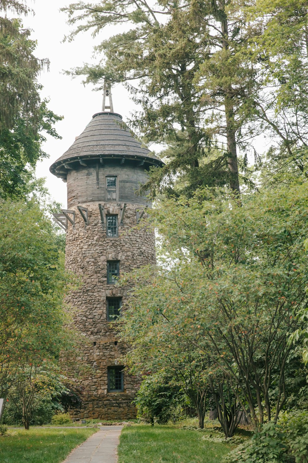 a stone tower in the middle of a forest