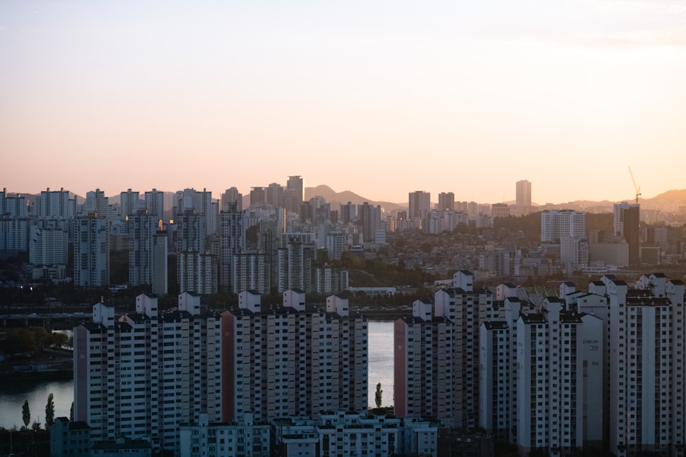 a city skyline with tall buildings and a body of water in the foreground