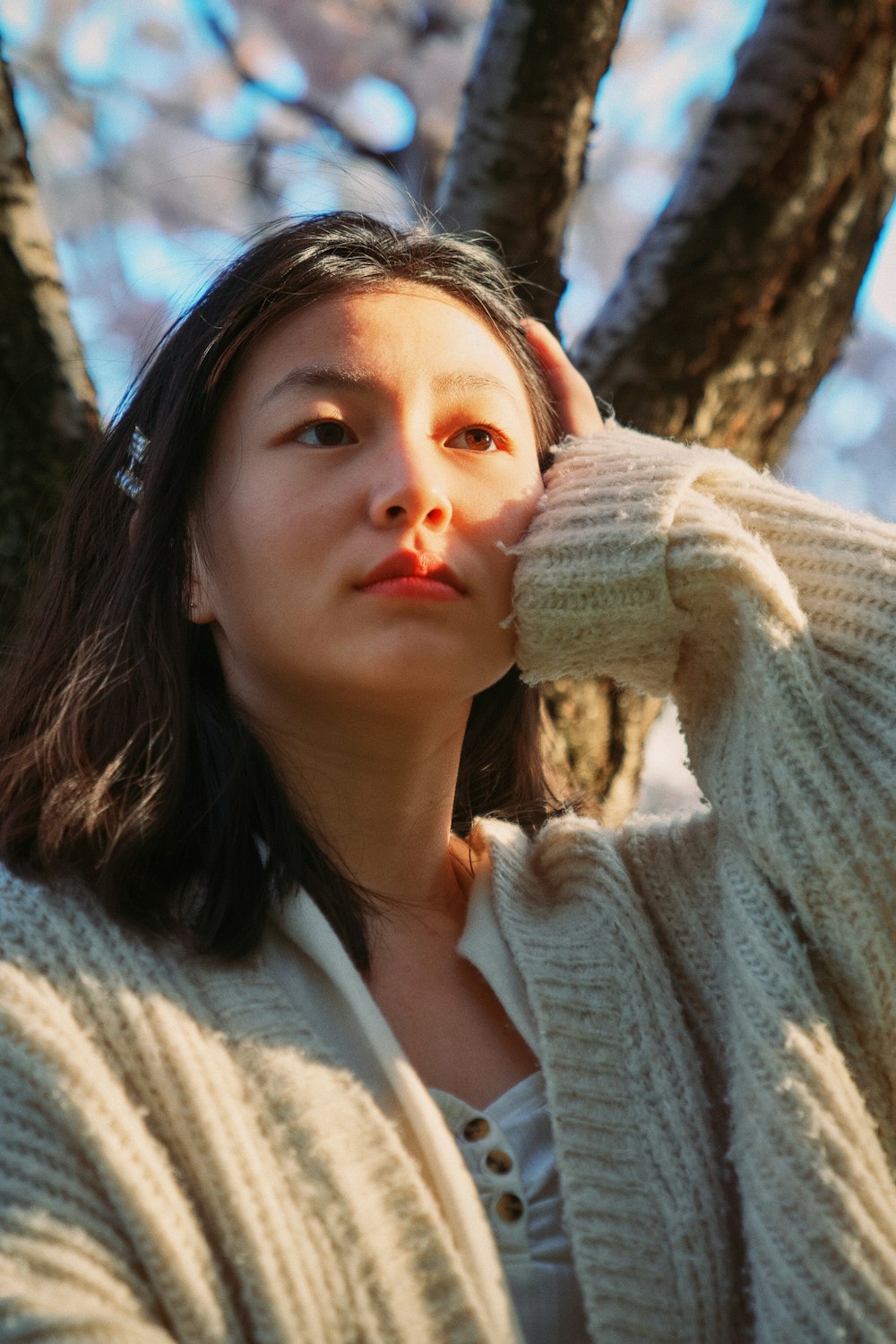 a woman standing in front of a tree