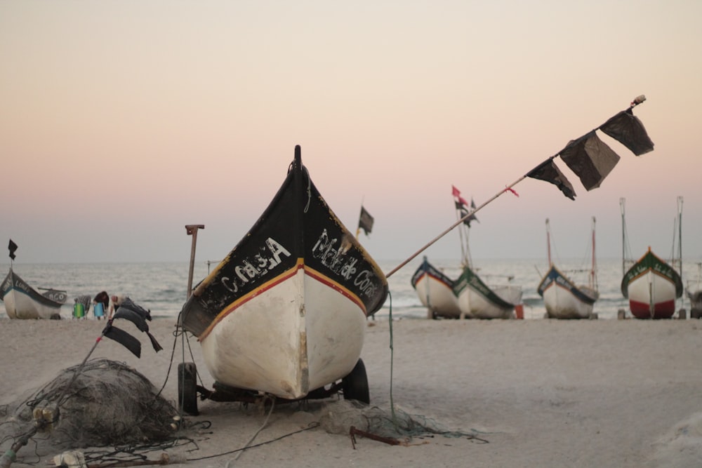 a row of boats sitting on top of a sandy beach