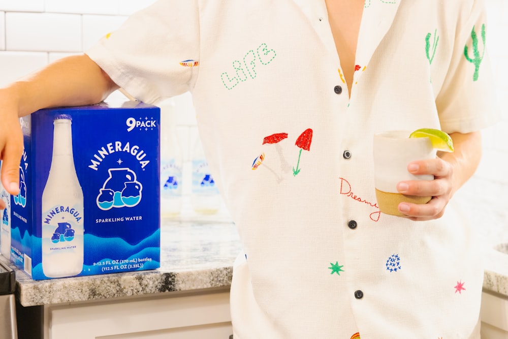 a woman holding a cup and a box of milk