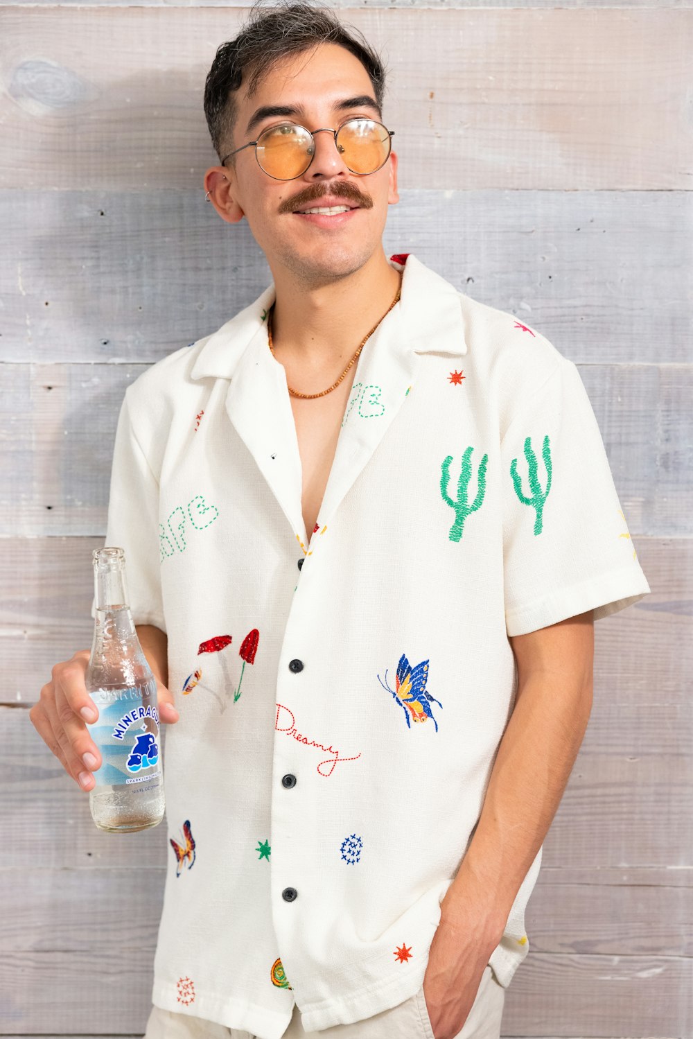 a man with a mustache and glasses holding a bottle of water