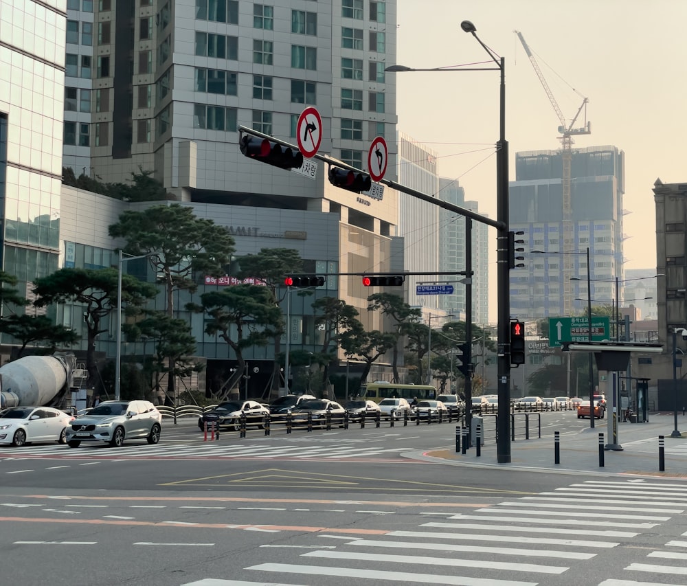 a city street filled with lots of traffic next to tall buildings