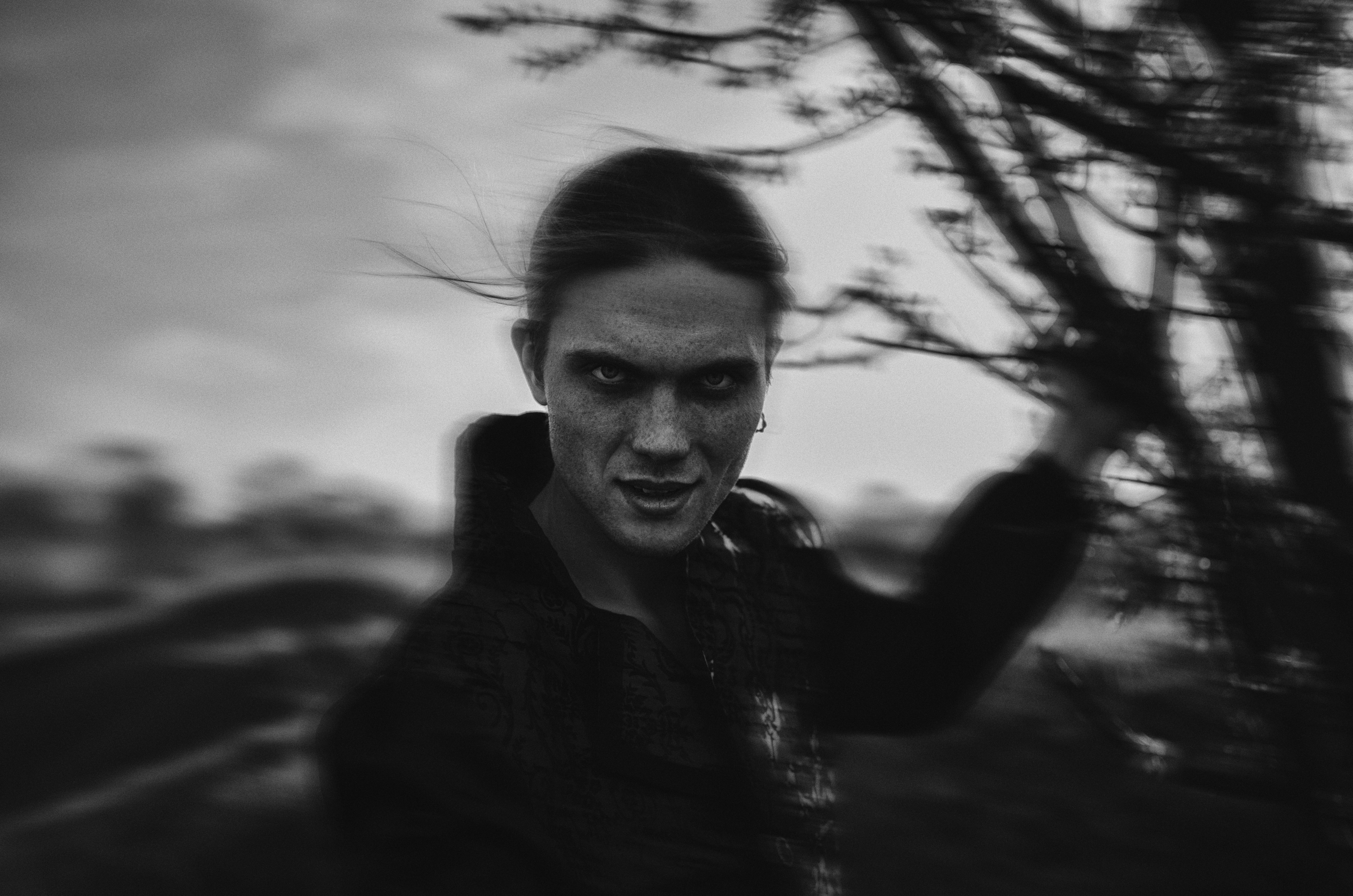 Black & white micture of a man with devilish eyes, slightly out of focus, giving the impression of being a vampire.