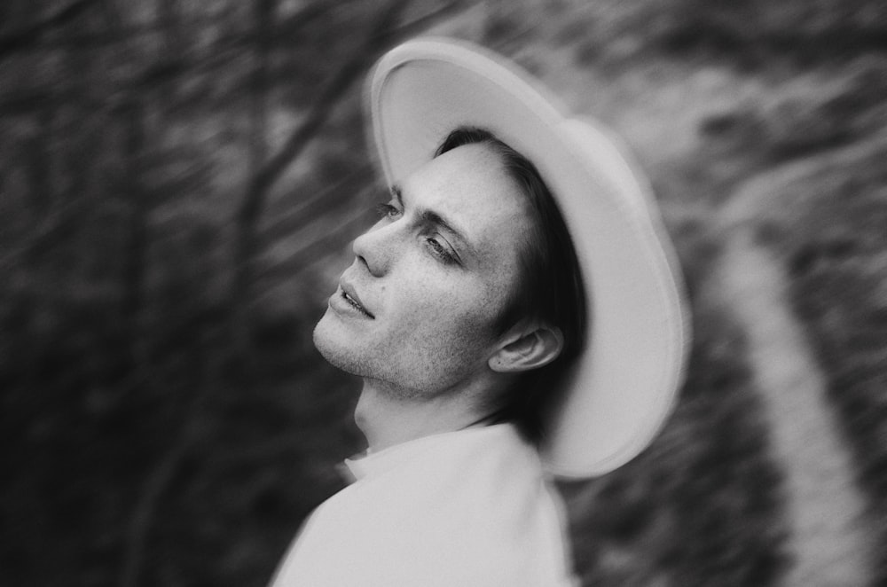 a man wearing a white hat standing in a field