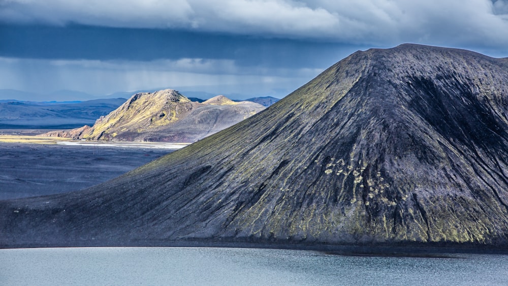 a mountain with a body of water in front of it