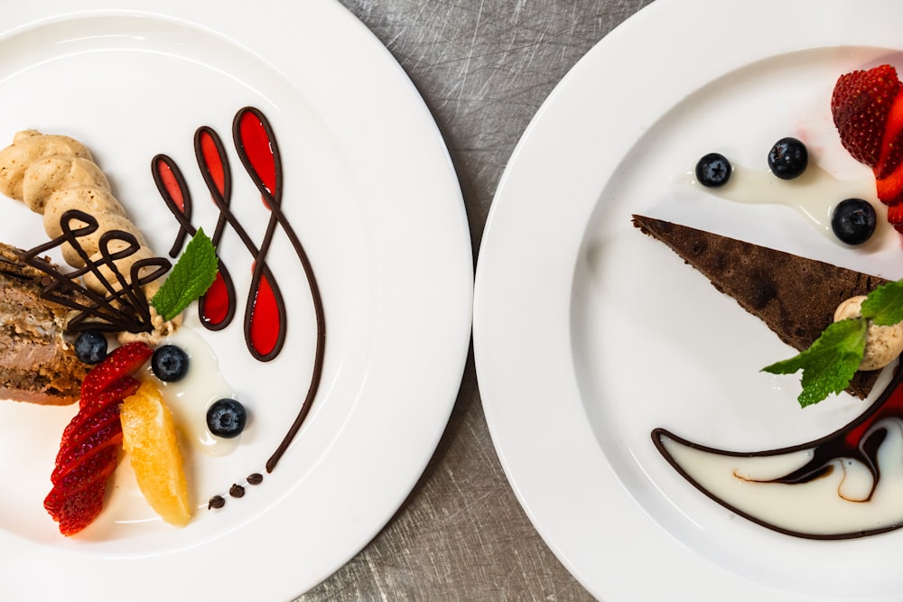 two white plates topped with different types of food