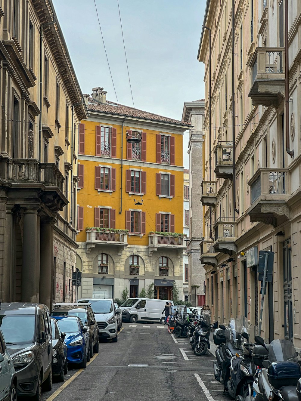 a street lined with parked motorcycles next to tall buildings