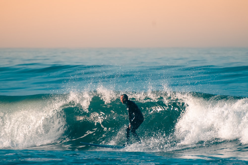 un uomo che cavalca un'onda in cima a una tavola da surf