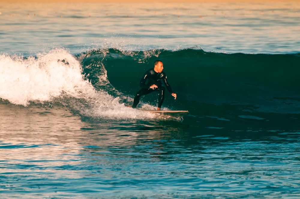 un uomo che cavalca un'onda in cima a una tavola da surf