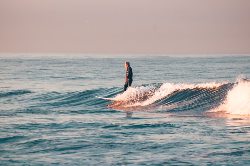 a man riding a wave on top of a surfboard