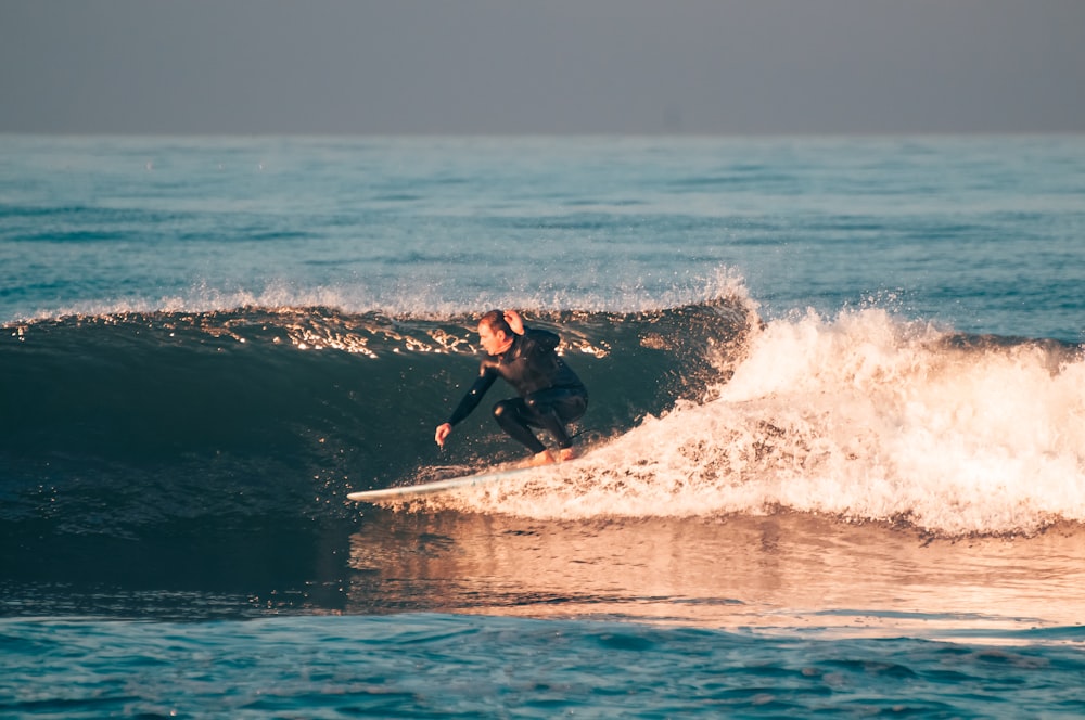 un uomo che cavalca un'onda in cima a una tavola da surf