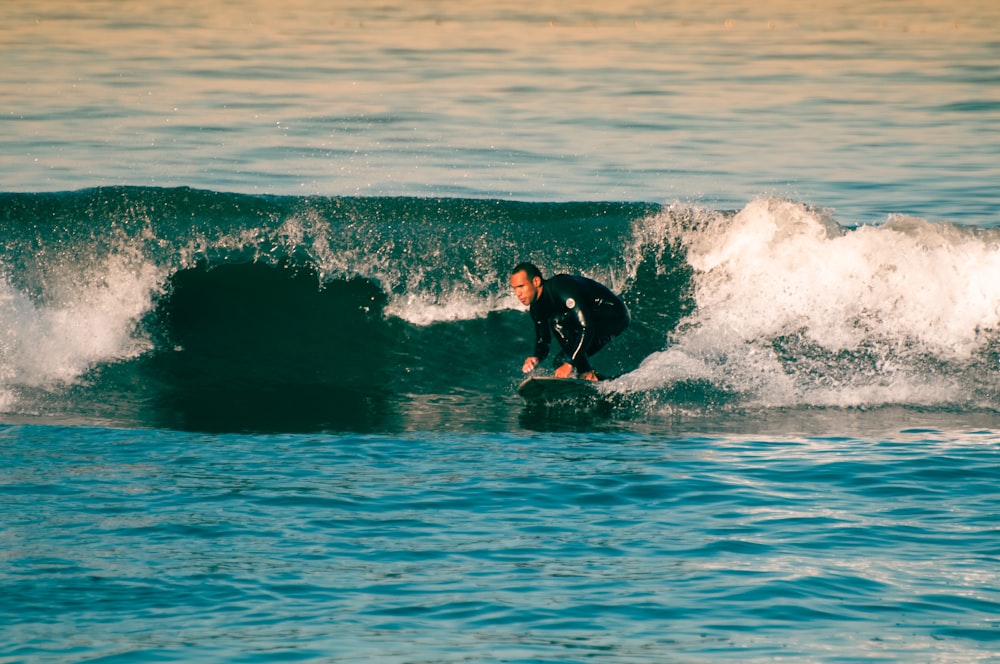 un uomo che cavalca un'onda in cima a una tavola da surf