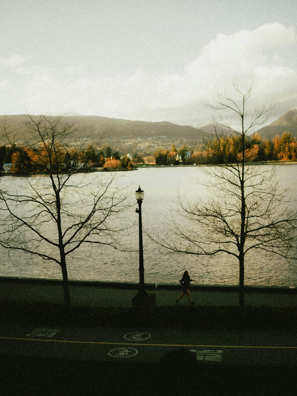 a person walking down a sidewalk next to a body of water