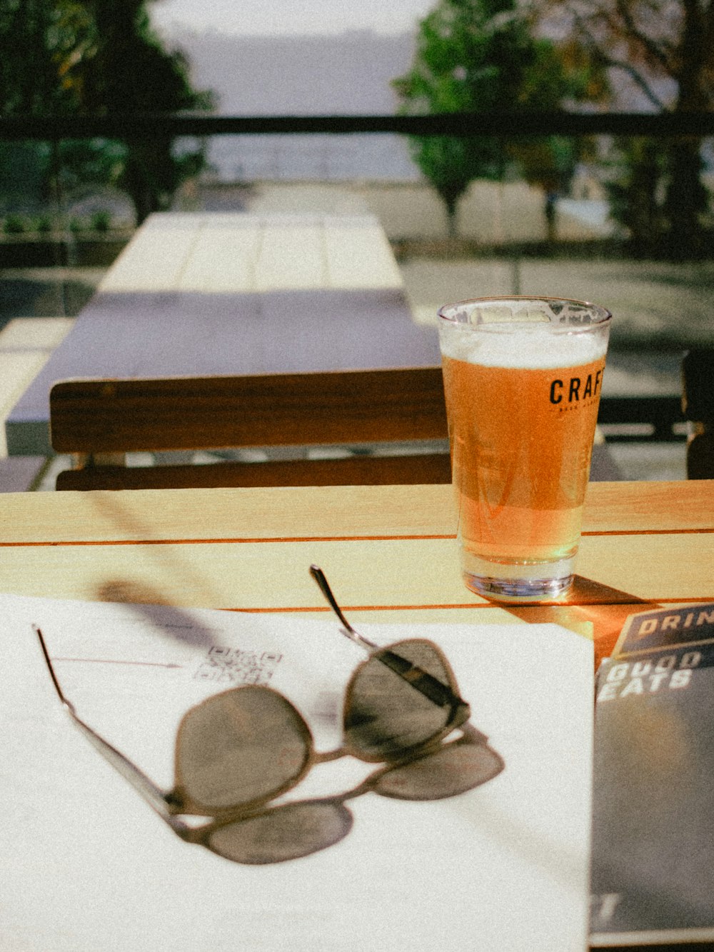 a glass of beer sitting on top of a table