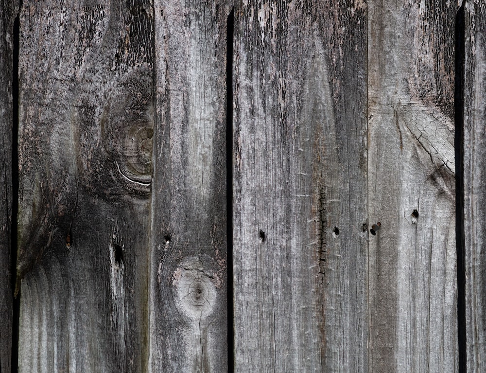 a close up of a wooden fence with peeling paint