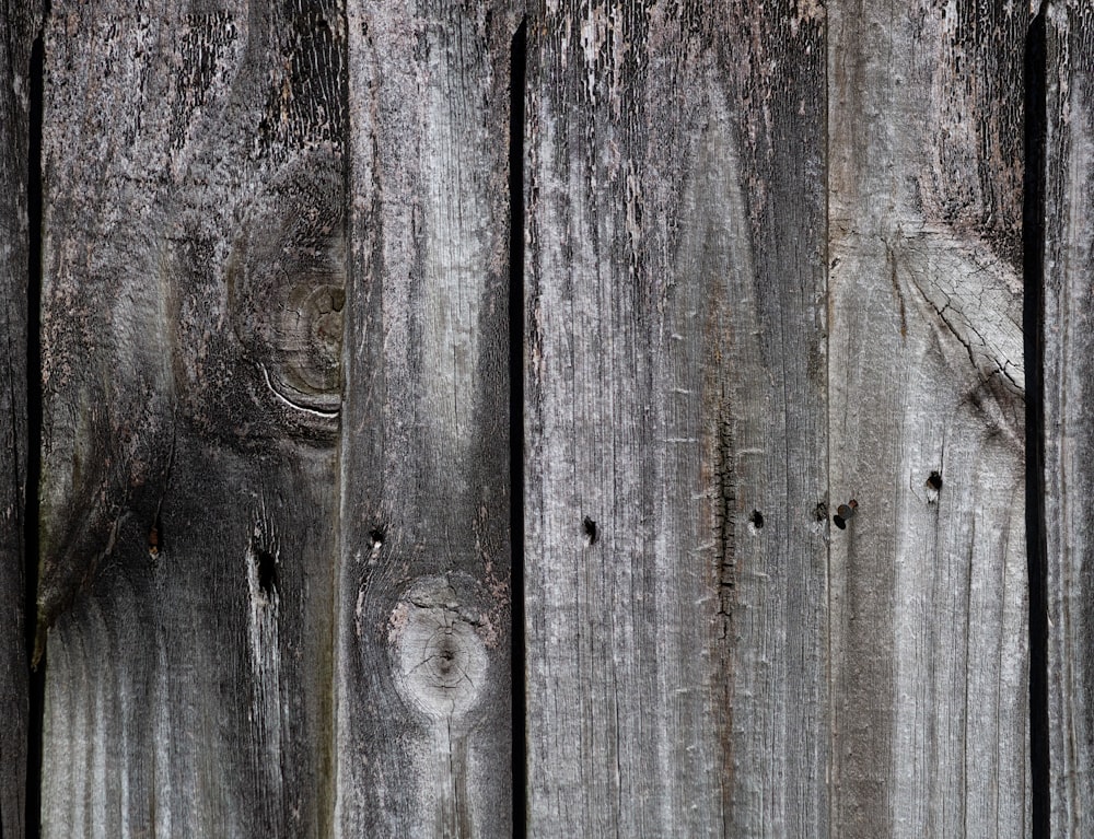um close up de uma cerca de madeira com tinta descascando