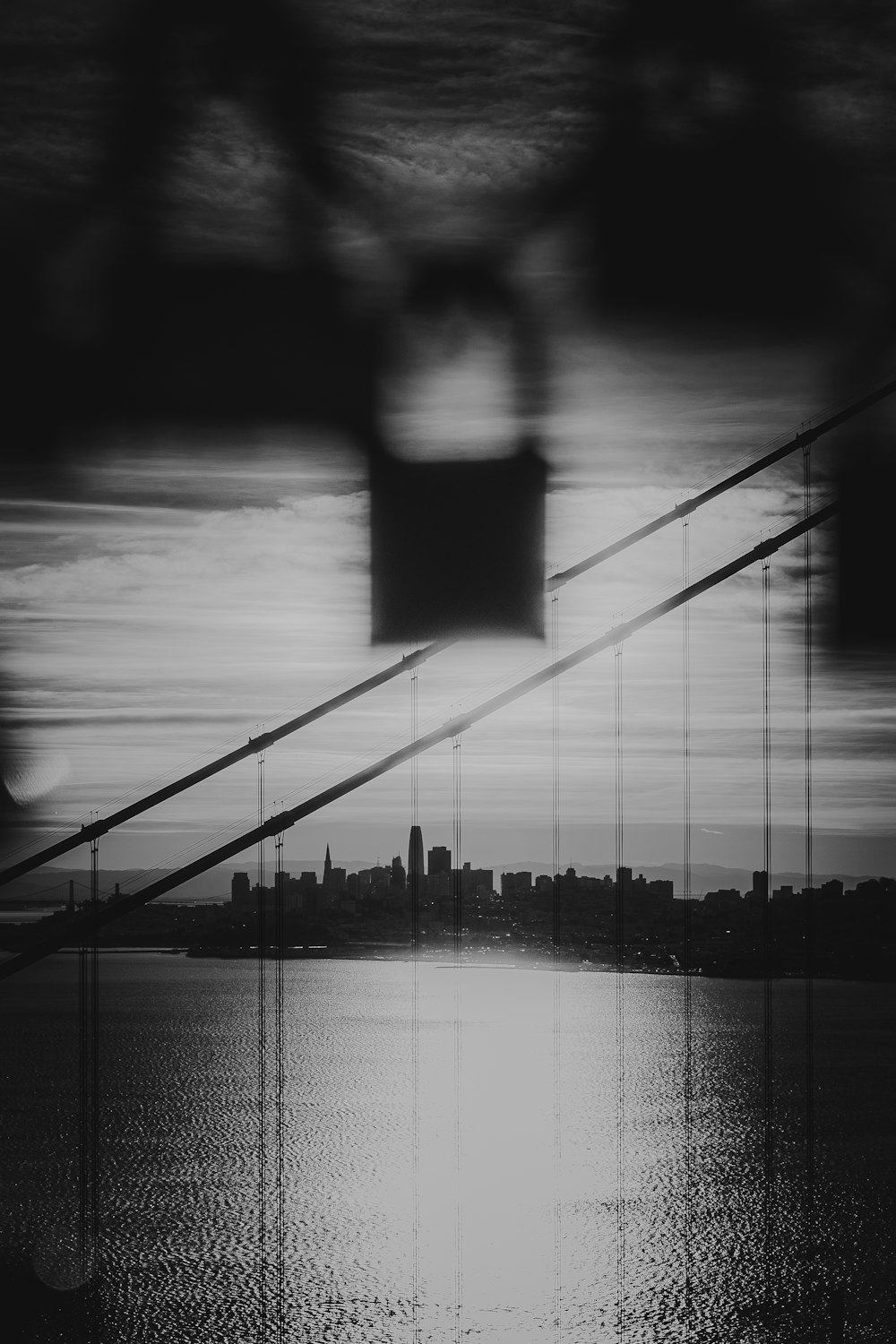 a black and white photo of a bridge over water