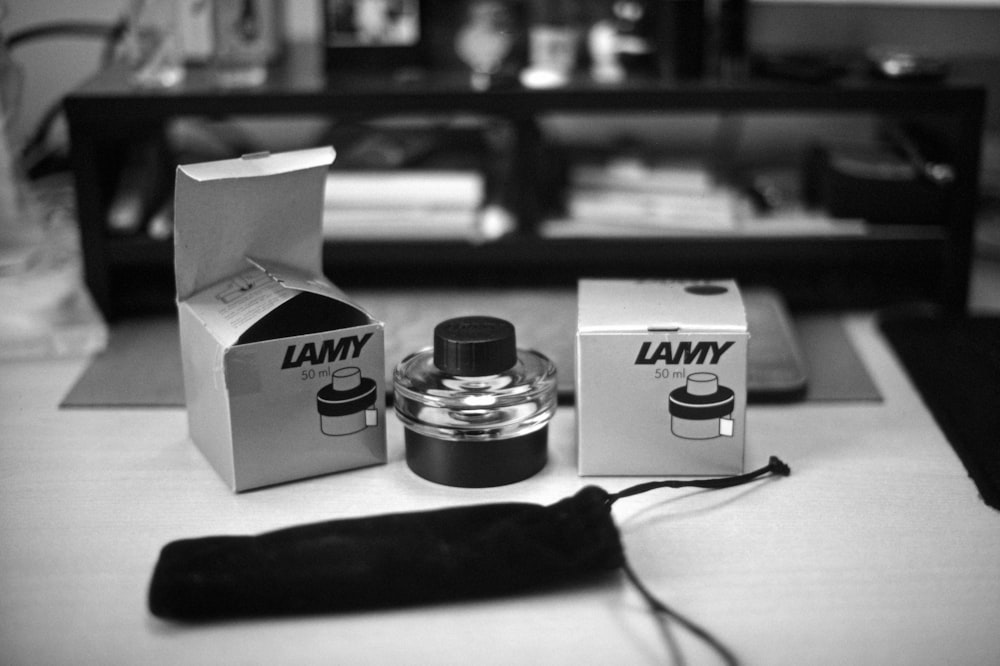 a black and white photo of a bottle and a box