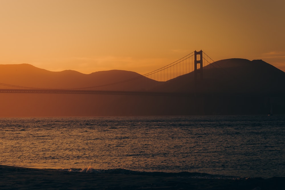 the golden gate bridge is silhouetted against the sunset