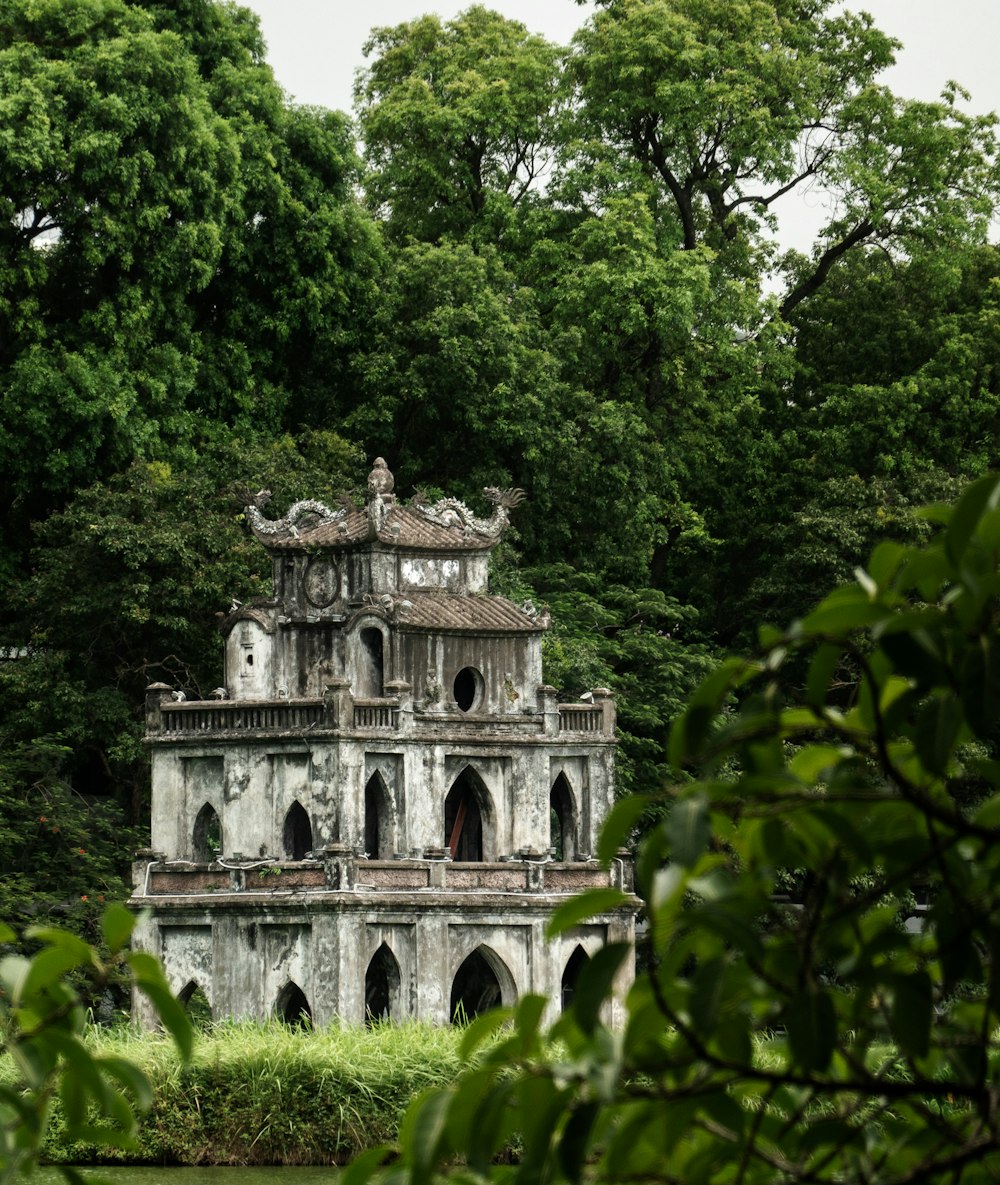 an old building sitting in the middle of a forest