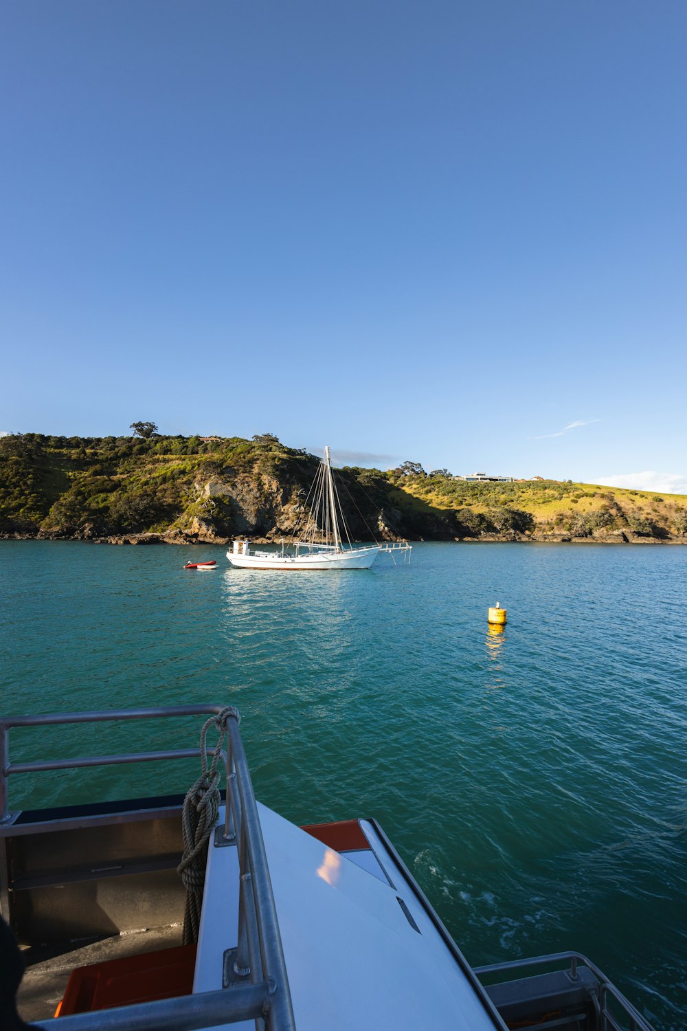 a boat in a body of water with a hill in the background