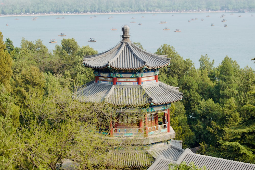 a tall pagoda sitting on top of a lush green hillside