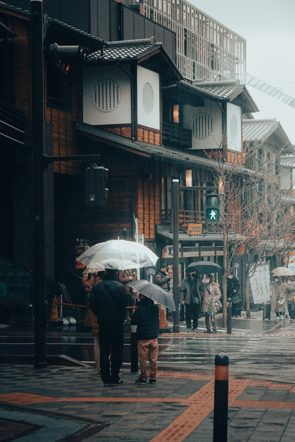 a group of people walking down a street holding umbrellas