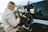 a man in a white jacket is putting a motorcycle in the back of a truck