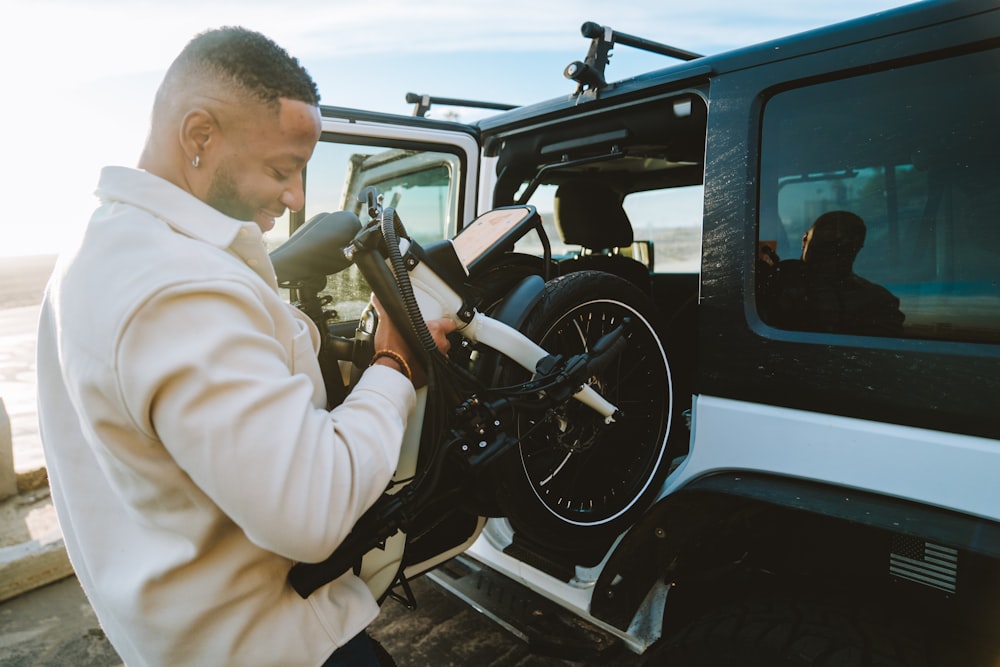 a man in a white jacket is putting a motorcycle in the back of a truck