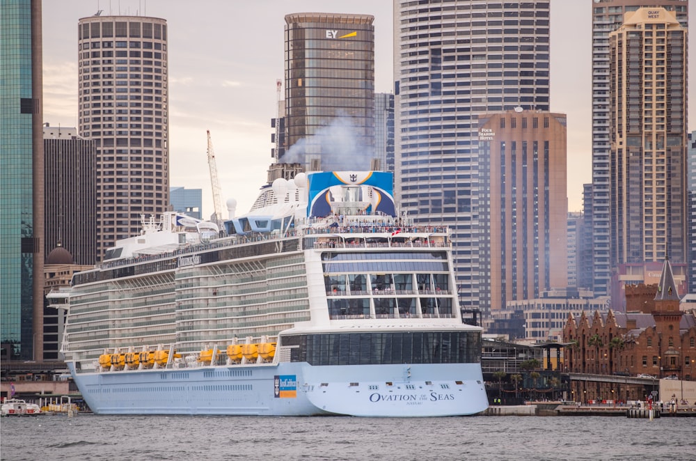 a cruise ship in the water with a city in the background