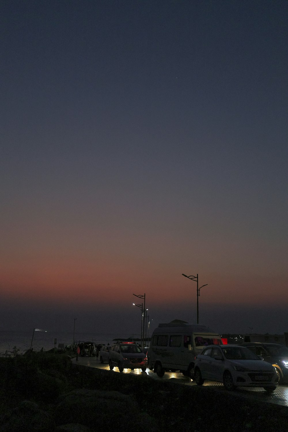 a parking lot filled with lots of cars next to the ocean