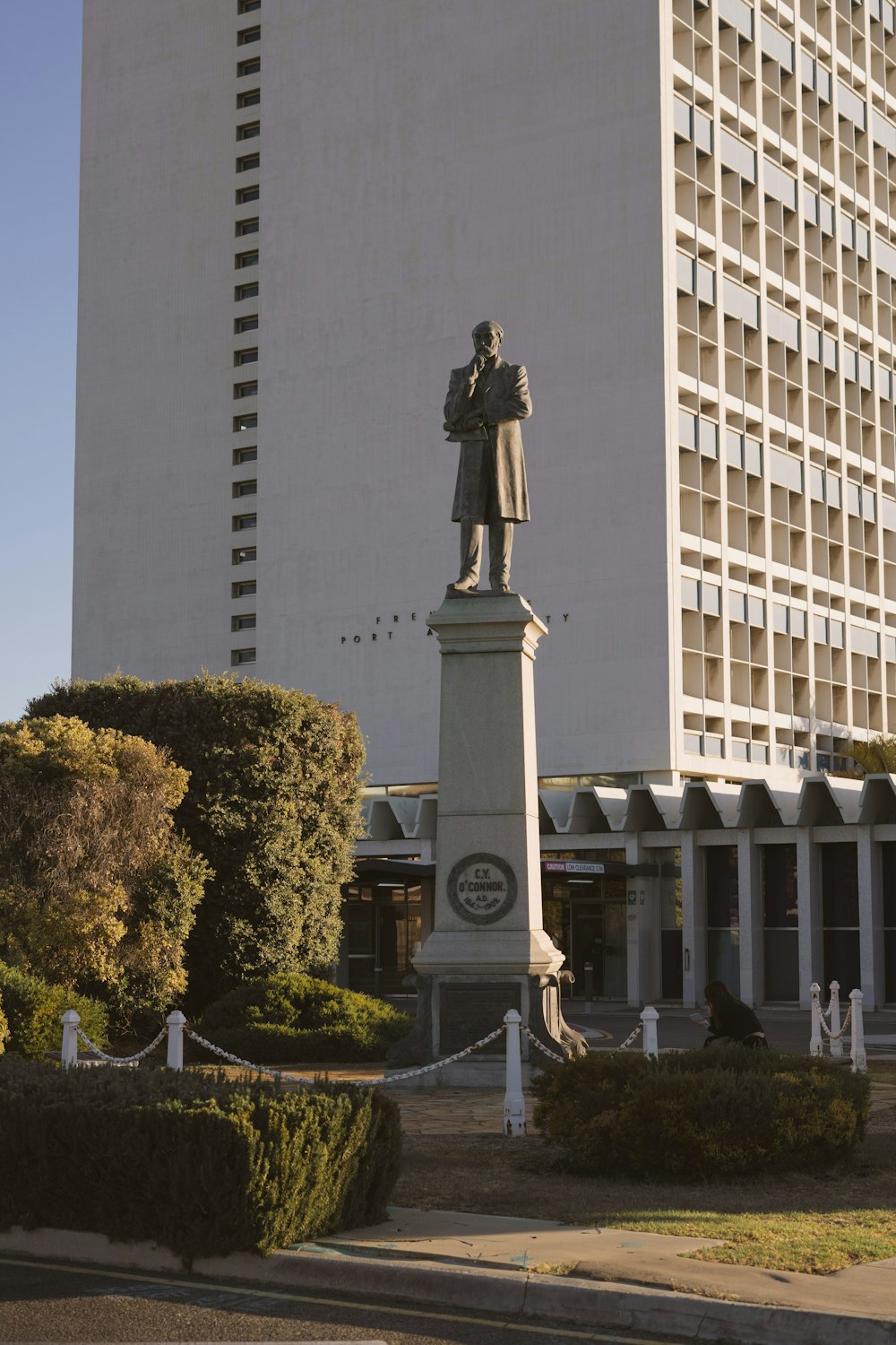 a tall white building with a statue in front of it