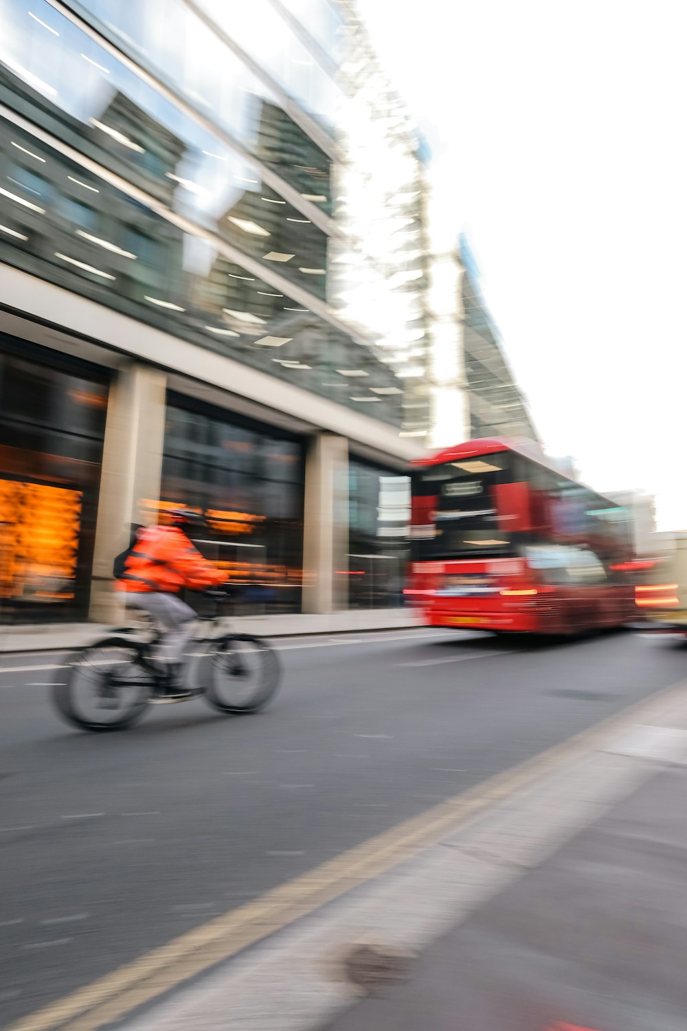 a red double decker bus driving down a street