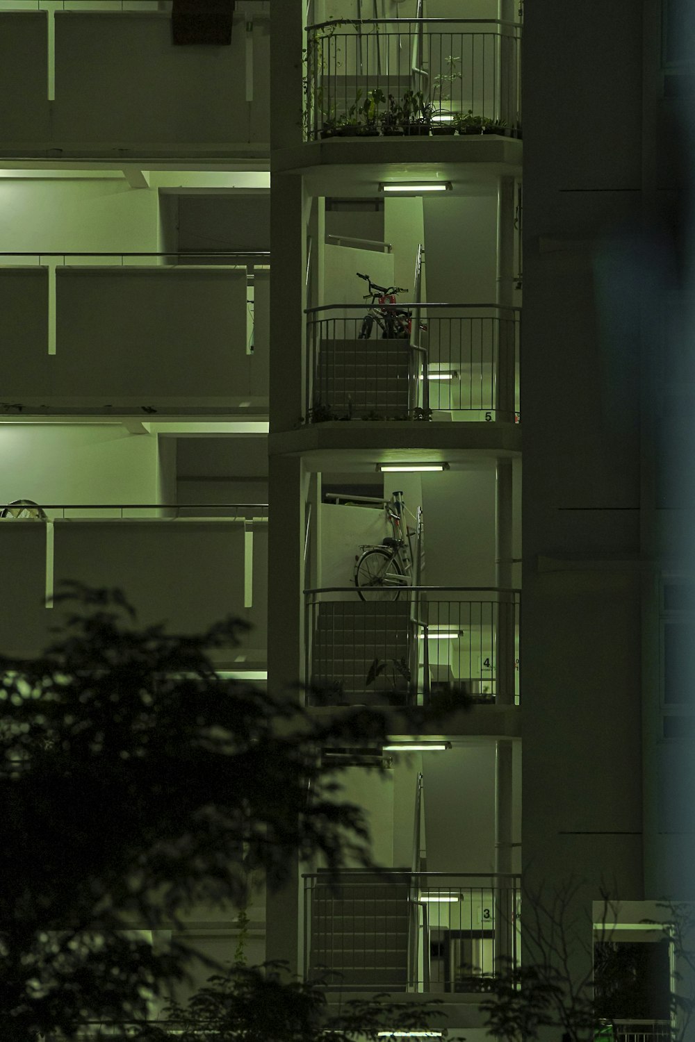 a tall building with several balconies and a bicycle parked in front of it