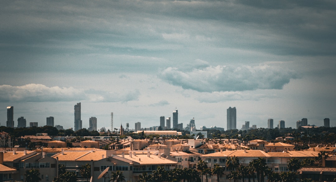 Cityscape view of Benidorm skyscrapers on the horizon and impressive, futuristic and possibly dystopian set against clouds and grey sky. A new chapter for this Costa Blanca resort, winter holidays and mass tourism in peak season.