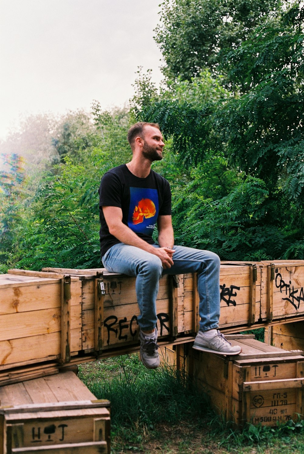 a man sitting on top of wooden crates