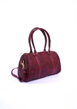 a red handbag sitting on top of a white table