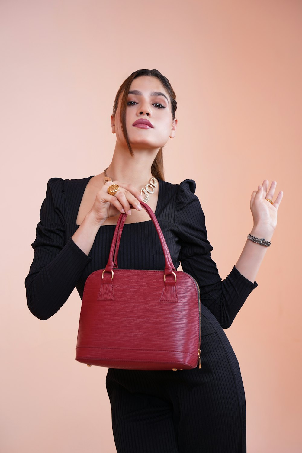 a woman holding a red purse and a donut