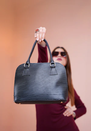 a woman in a red dress holding a black purse