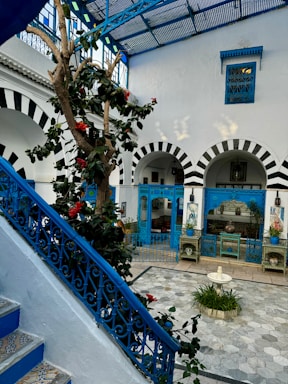 a blue and white building with a tree in the middle